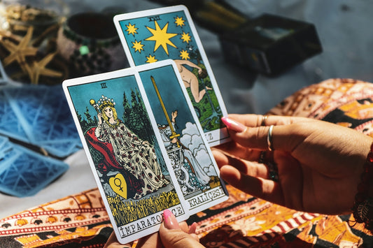A person holding two tarot cards in their hands