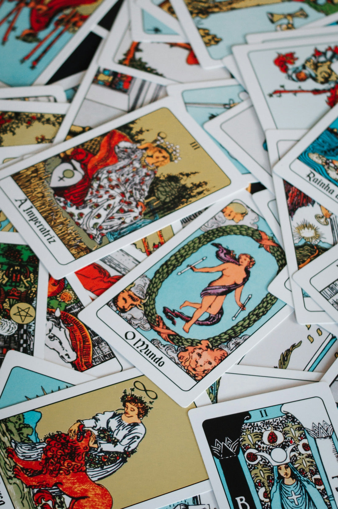 A pile of scattered tarot cards with colorful illustrations