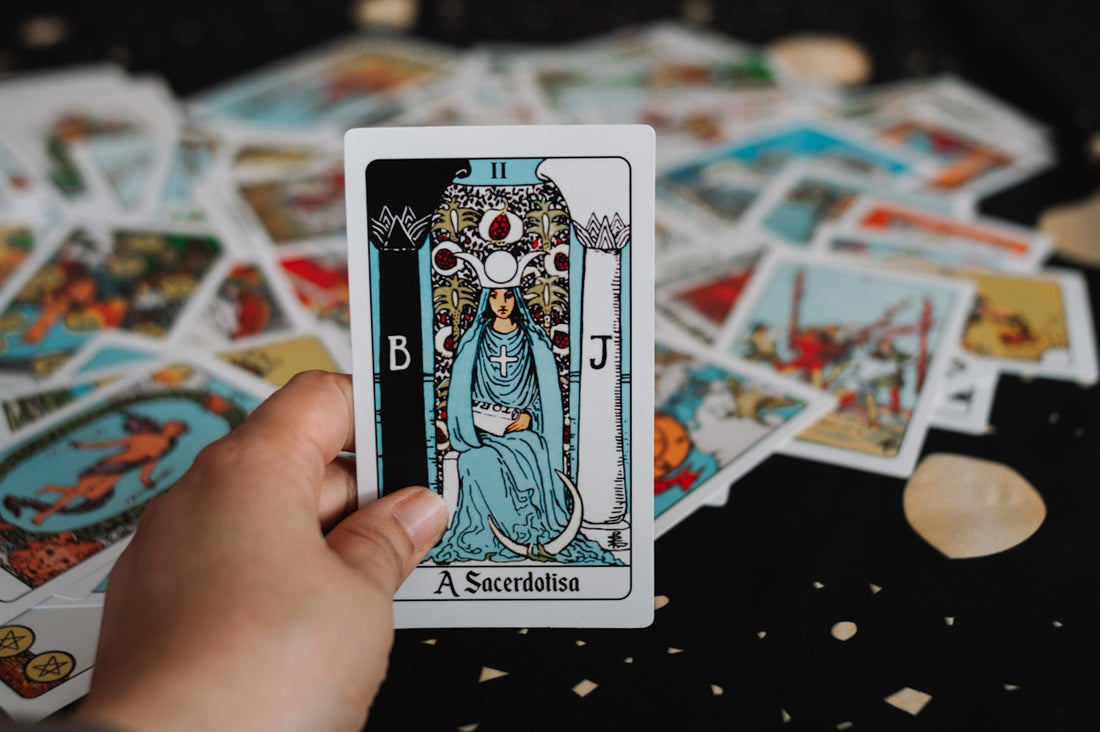 Hand holding a tarot card over a spread