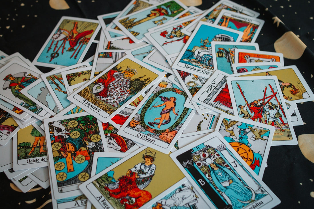 A pile of scattered tarot cards with colorful illustrations
